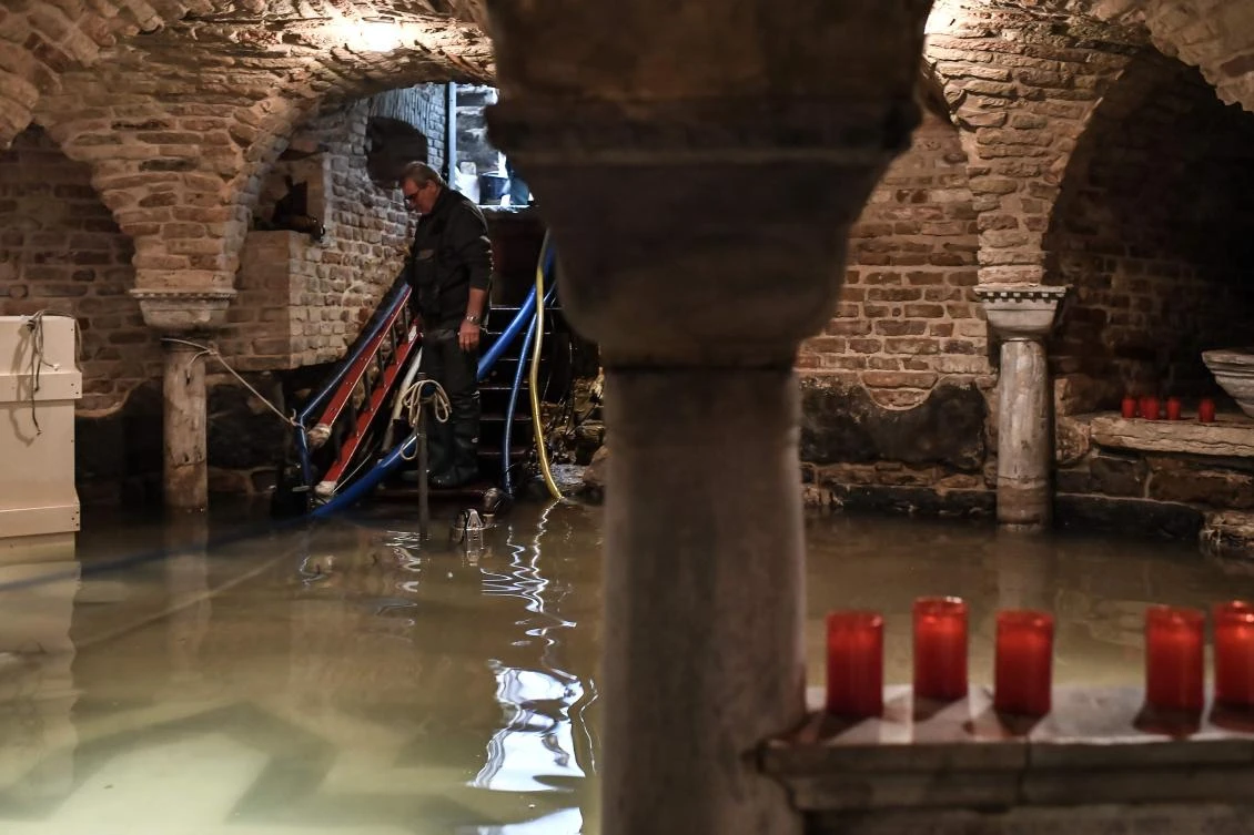 A man pumps out water from the flooded crypt of St. Mark's Basilica after an exceptional overnight "Alta Acqua" high tide water level, on November 13, 2019 in Venice. (File/AFP)