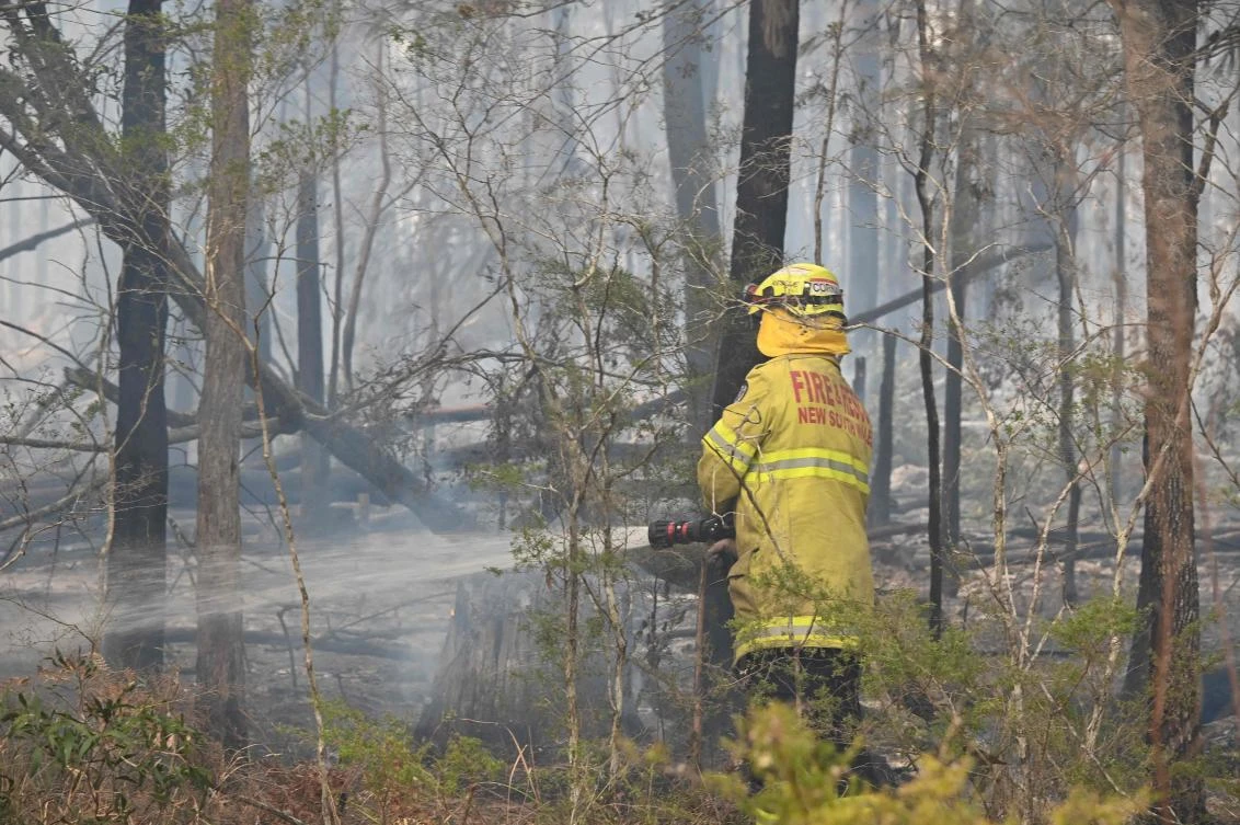 A firefighter puts spot fires out in Old Bar, 350km north of Sydney on November 11, 2019. (File/AFP)