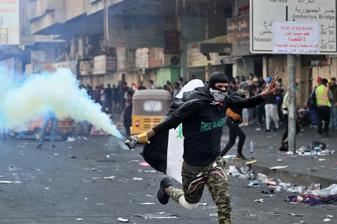 An anti-government protester prepares to throw back a tear gas canister fired by police during clashes at Khilani Square in Baghdad, Iraq, Thursday, Nov. 14, 2019. (AP)