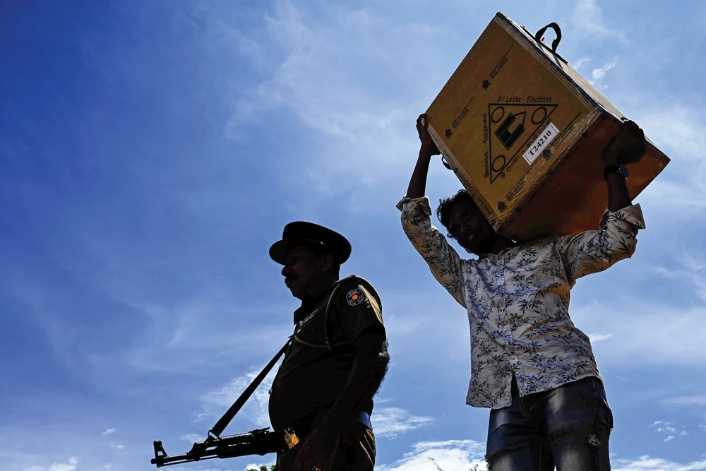 Sri Lankan police and electoral officials collect ballot papers and boxes from a distribution center on Friday for their respective polling stations. AFP