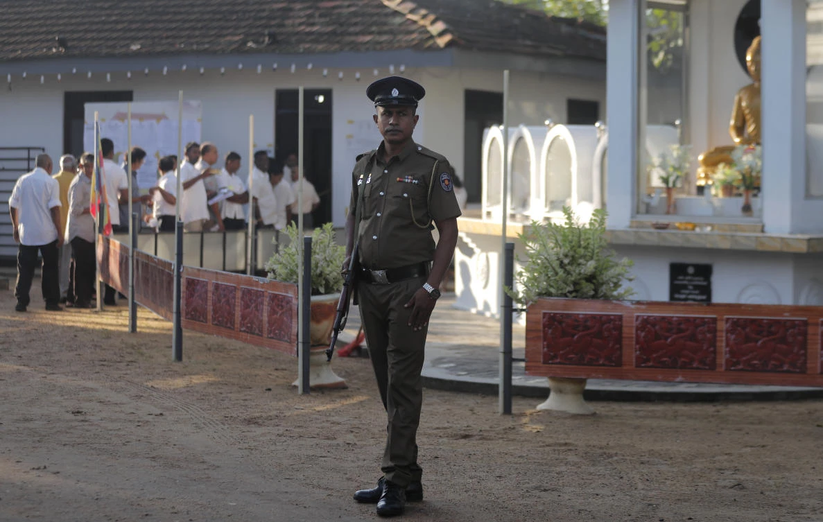 Sri Lankans queue up to cast their votes as a police officer stands guard at a polling station during the presidential election in Colombo, Sri Lanka, Saturday, Nov. 16, 2019. (AP)