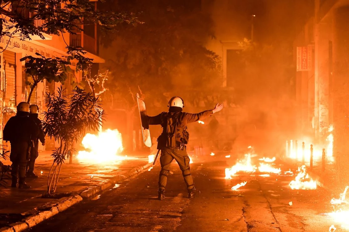 An anti-riot policeman walks past flames as a petrol bomb exploded in downtown Athens during clashes on November 17, 2018 against demonstrators. (AFP file)