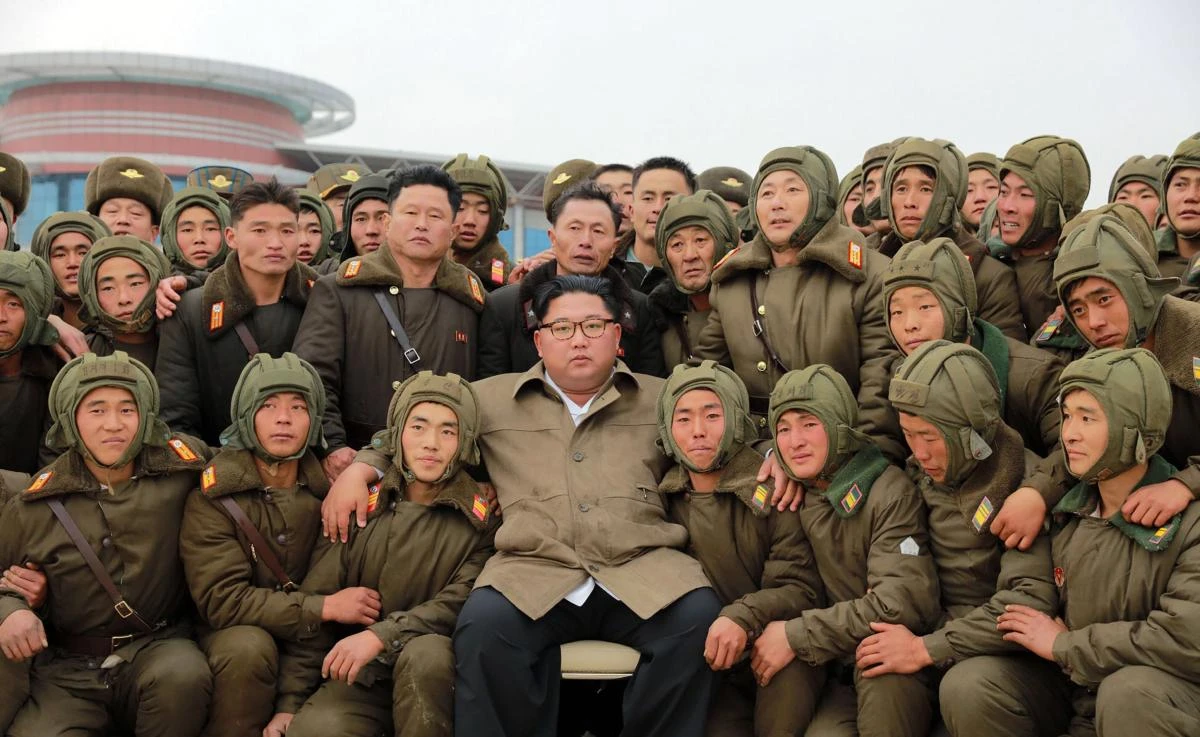 North Korean leader Kim Jong Un pose with air and anti-aircraft force personnel during an airborne insertion training at an undisclosed location. (KCNA via KNS/AFP)