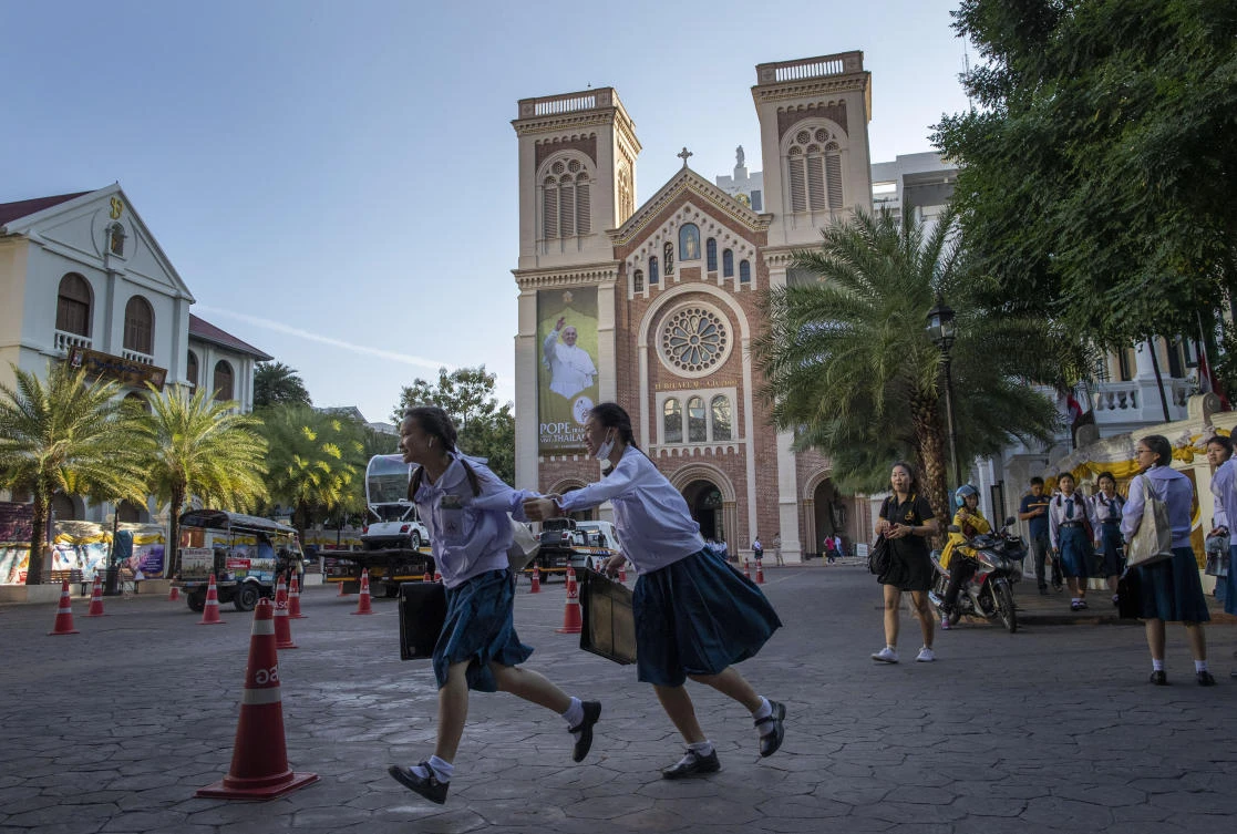 School children run in the courtyard of Assumption Cathedral, which was decorated with posters of Pope Francis, in Bangkok on Wednesday, Nov. 20, 2019. (AP)