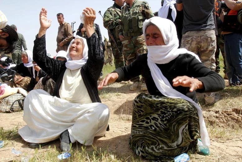 Members of the Yazidi minority sect who were newly released wait along a road on the outskirts of Kirkuk, April 8, 2015. (Reuters)