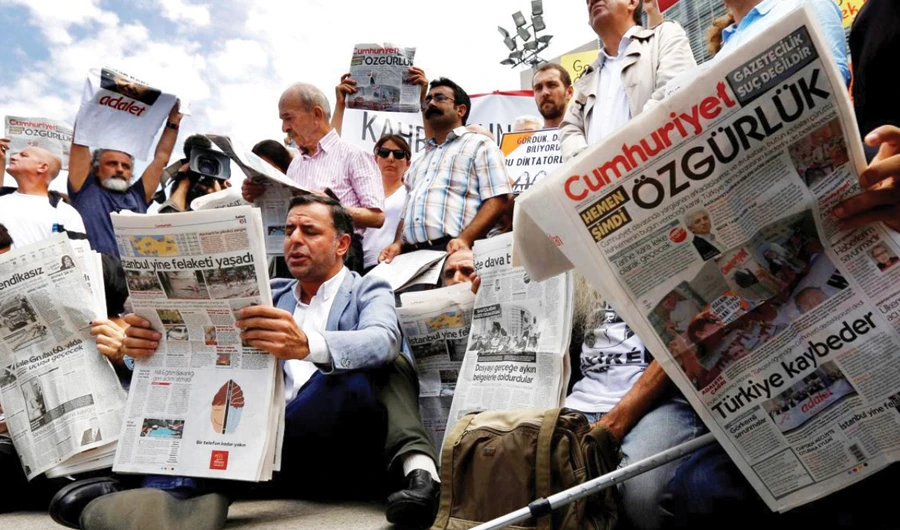 Press freedom activists read opposition newspaper Cumhuriyet during a demonstration outside a courthouse, in Istanbul in this file photo. (Reuters)