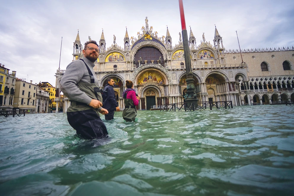 A man wades through a flooded street near the Rialto bridge in Venice. Environmentalists have blamed dramatic flooding in the city on climate change. (AFP)