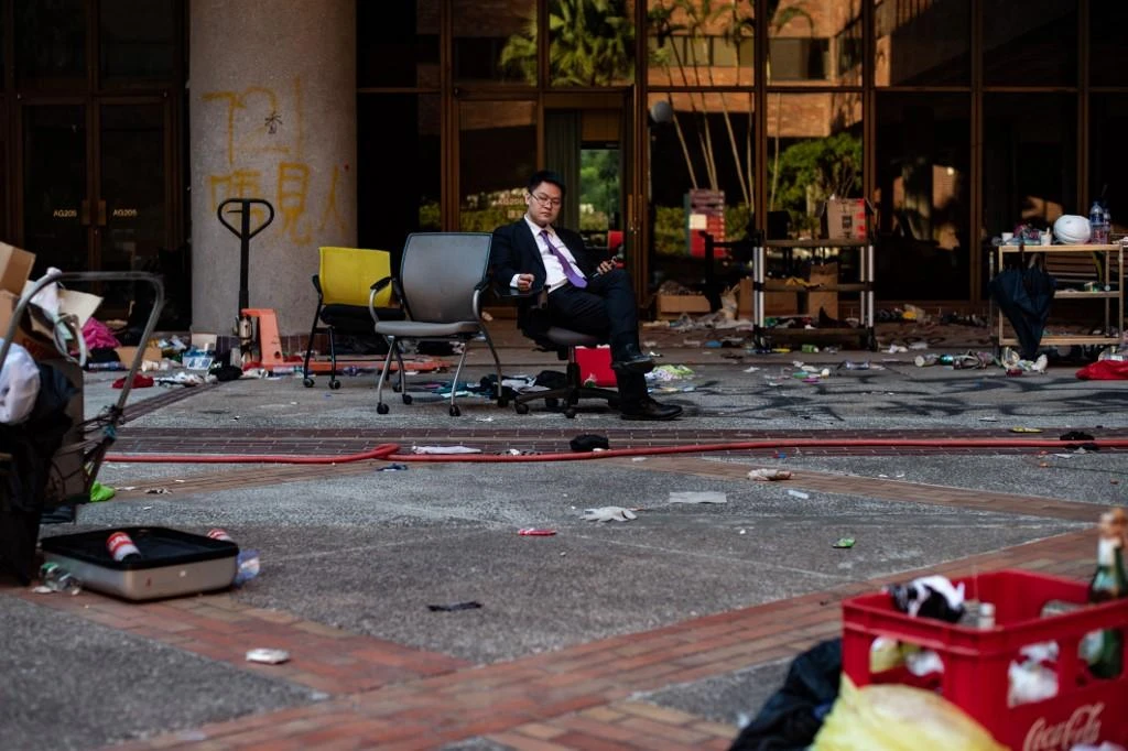 Hong Kong police allowed citizens to mill about the edges of the Polytechnic University campus cordon as neighborhood shops opened for business. (AFP)