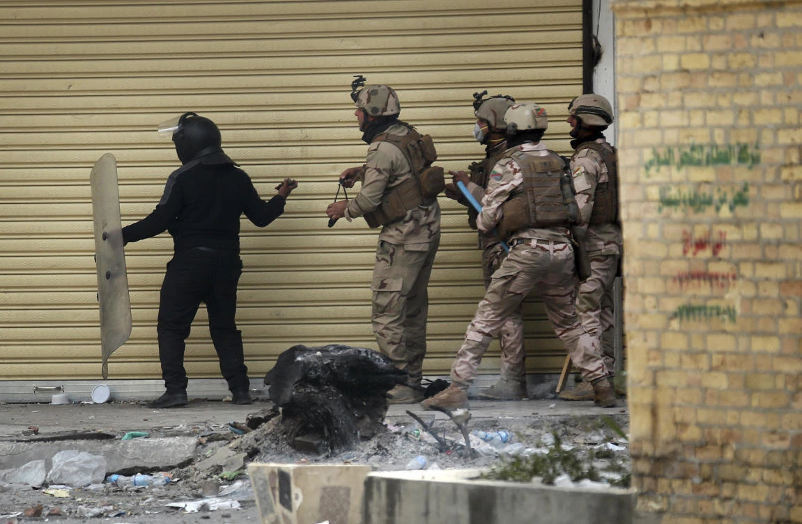 Iraqi security forces try to disperse anti-government protesters during clashes in Baghdad on Saturday. (AP)
