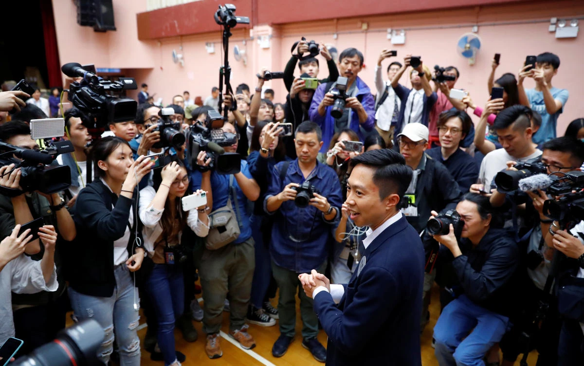 Members of the media interview Kelvin Lam, who won the South Horizons West seat, was drafted to contest the seat for the pro-democracy camp after prominent activist Joshua Wong was barred from standing. (Reuters)