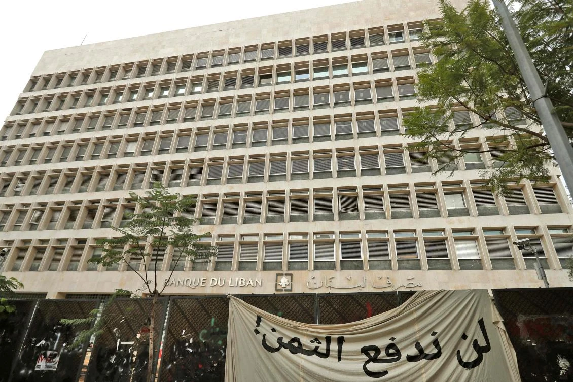 This picture taken on November 27, 2019 shows a banner in Arabic reading "we will not pay the price" hanging outside the headquarters of the Banque du Liban (Lebanese Central Bank) in Beirut, Lebanon. (AFP)