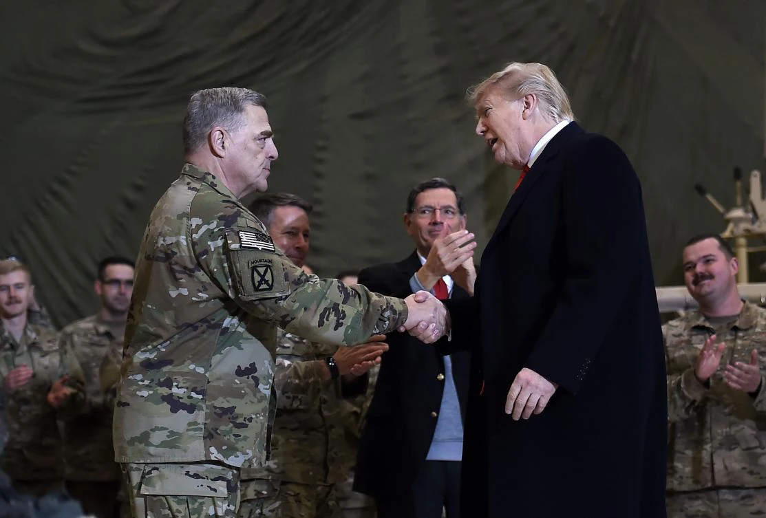 US President Donald Trump shakes hands with Joint Chiefs Chairman General Mark Milley before addressing the troops at Bagram Air Field during a surprise Thanksgiving day visit, on November 28 in Afghanistan. (AFP)