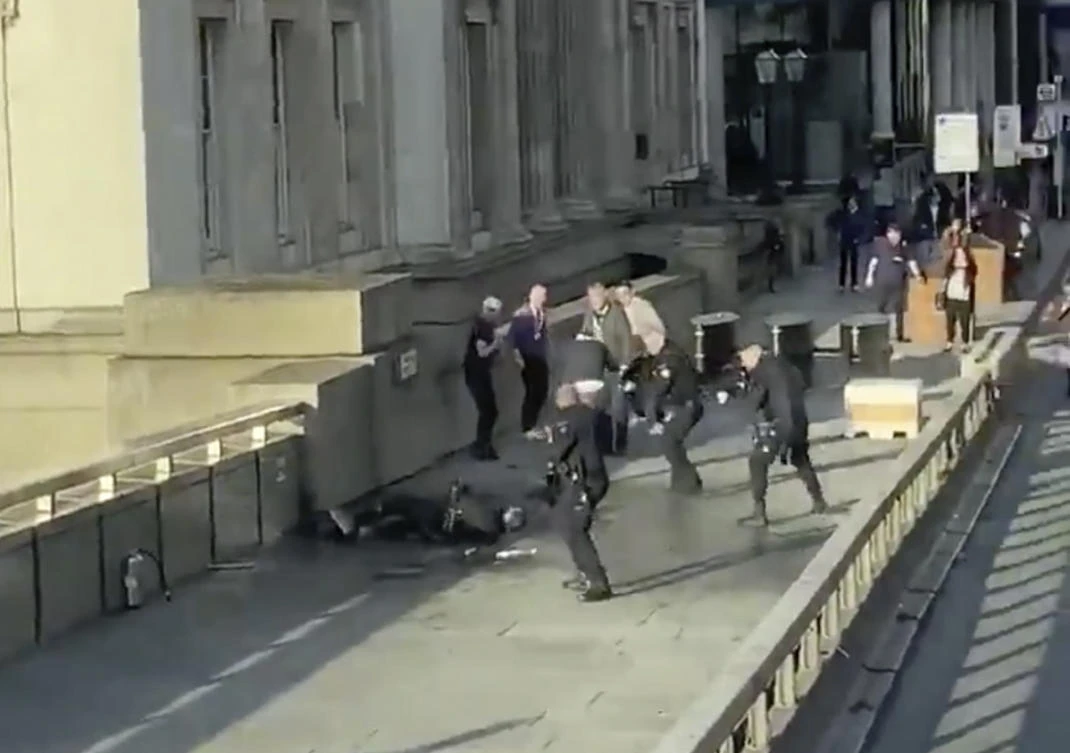 An image grab taken from a video shows a man surrounded by police after an incident on London Bridge on Friday, Nov. 29, 2019. (@HLOBlog via AP)