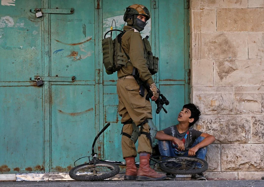 An Israeli soldier detains a Palestinian boy during an anti-Israel protest in Hebron in the Israeli-occupied West Bank on Friday.. REUTERS/Mussa Qawasma