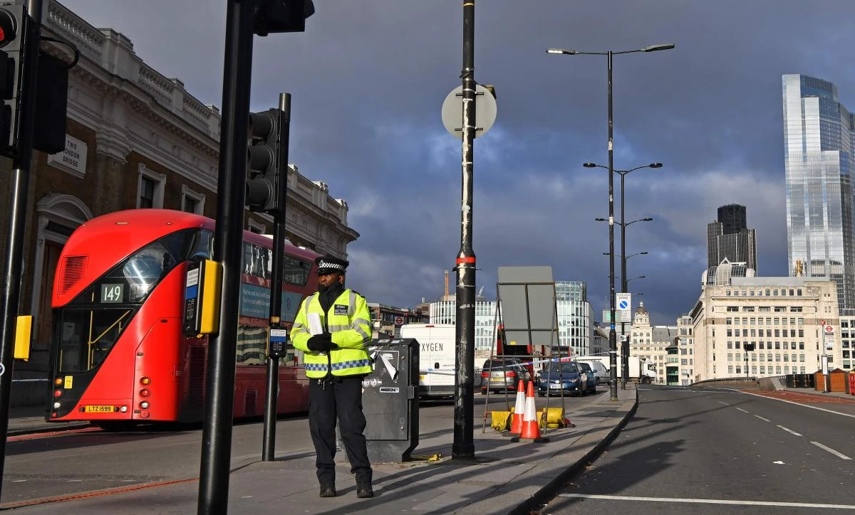 Cars, buses and lorries remain in position as police officer stands guard inside a cordon on the south side of London Bridge in the City of London, on December 1, 2019, following the November 29 deadly terror incident. (AFP)