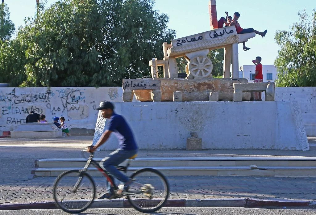 A Tunisian child waves atop a monument on Bouazizi street on August 15, 2019 in the central Tunisian town of Sidi Bouzid, which nine years ago saw the start of the Arab Spring movements that brought down multiple autocrats in the Arab world (AFP/ File Photo).