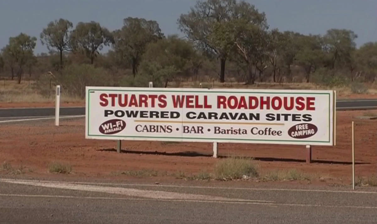 In this image made from video, an advertisement for the campsite line the roadside where a woman was found after being stranded in the Alice Springs area in the central Australian Outback. (AP)