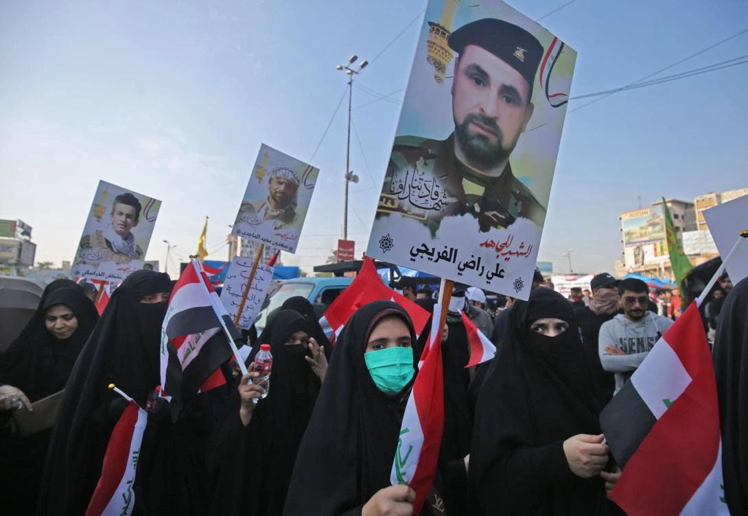 Iraqi supporters of the Hashed Al-shaabi armed network, carry pictures of fighters killed in fighting against jihadists, as they demonstrate in the capital Baghdad's Tahrir Square on December 5, 2019. (AFP)