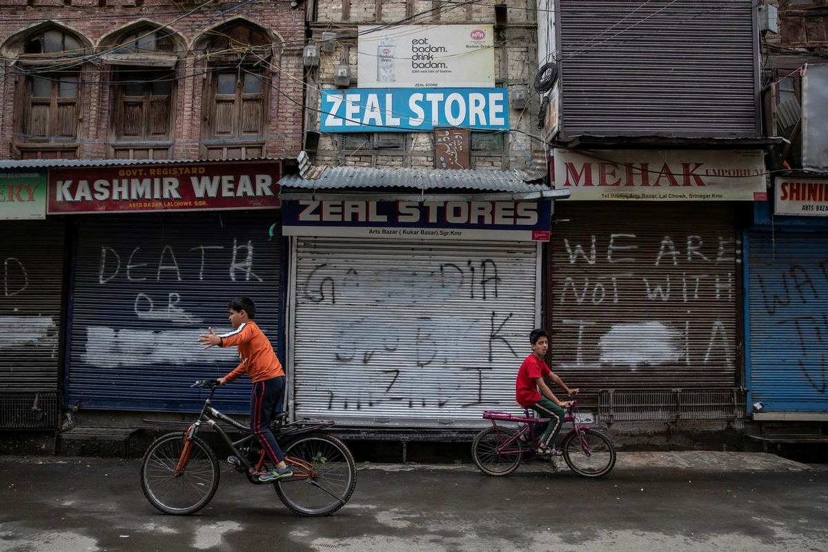 Kashmiri boys cycle in an empty Srinagar street during restrictions after the scrapping of the special constitutional status for Kashmir by the government. (Reuters)