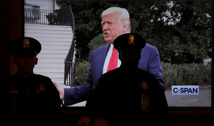 US Capitol police officers stand in front of a video showing President Donald Trump speaking to the news media in the White House driveway as it is displayed on a screen in the House Judiciary Committee’s first hearing on the impeachment inquiry into Trump on Capitol Hill in Washington on Dec. 4, 2019. (REUTERS/Jonathan Ernst)