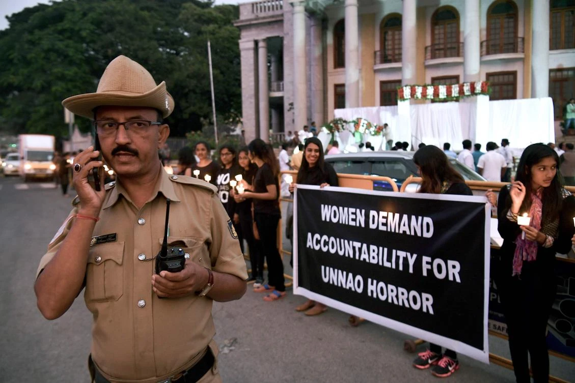A policeman speaks on his phone as people hold a candlelight vigil in support of sexual assault victims and against the alleged rape and murder of a 27-year-old veterinary doctor in Hyderabad, in Bangalore on December 6, 2019. (AFP)