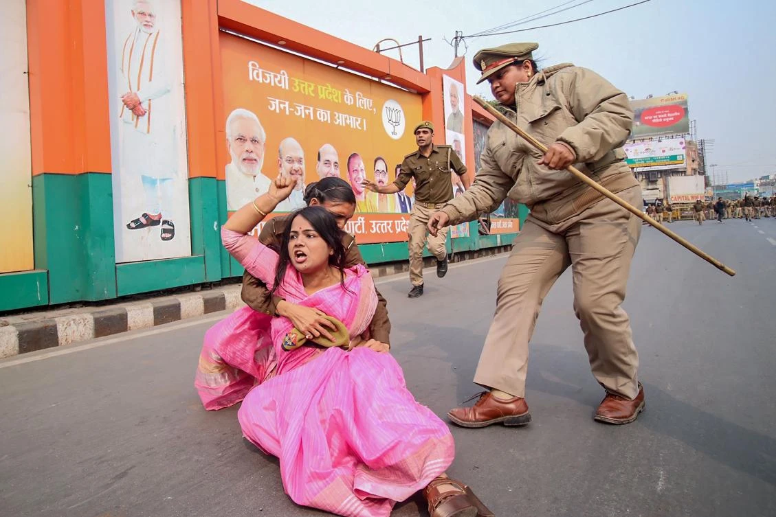 A Samajwadi Party activist (C in pink) is being held by police personnel as she protests against the Unnao rape case during a demonstration at Vishan Sabha, the seat of the legislature of Uttar Pradesh state, in Lucknow on December 7, 2019. (AFP)