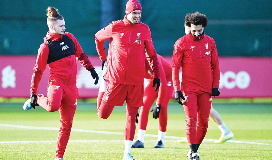 From left, Liverpool's midfielder Harvey Elliott, defender Dejan Lovren and midfielder Mohamed Salah stretch during a training session on Monday. AFP)