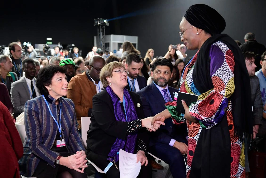 United Nations High Commissioner for Human Rights Michelle Bachelet shakes hands with an atendee beside Spanish government’s caretaker spokeswoman and minister of education Isabel Celaa as they take part in the event “We Dare” : Children and Youth vs. Climate Change. (File/AFP)