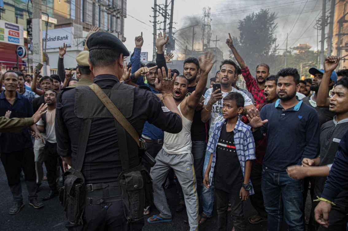 An Indian commando tries to stop as protesters block traffic during a shutdown protest against the Citizenship Amendment Bill (CAB) in Gauhati, India, Tuesday, Dec. 10, 2019. (AP)