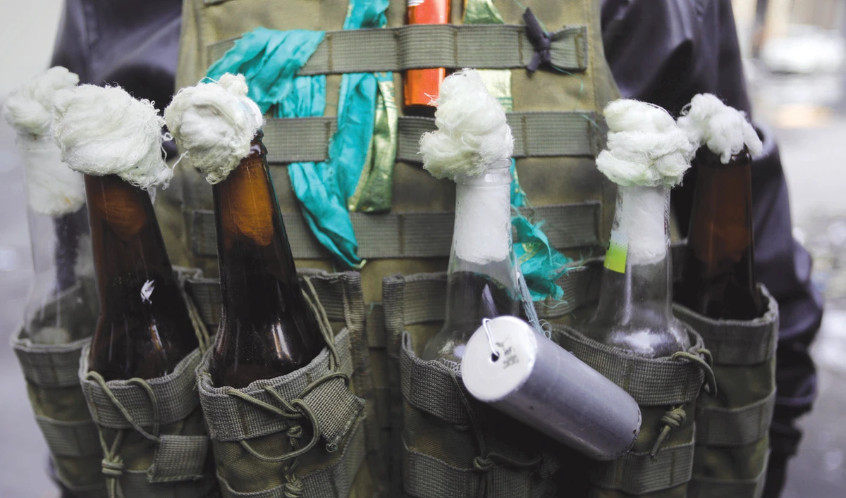 An Iraqi demonstrator carries molotov cocktails during ongoing anti-government protests in Baghdad on Thursday. (Reuters)