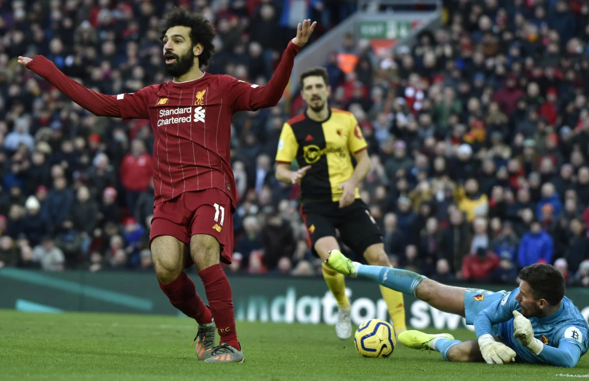 Liverpool's Mohamed Salah, left, gestures as Watford's goalkeeper Ben Foster makes a save during the English Premier League soccer match between Liverpool and Watford at Anfield stadium in Liverpool. (AP)