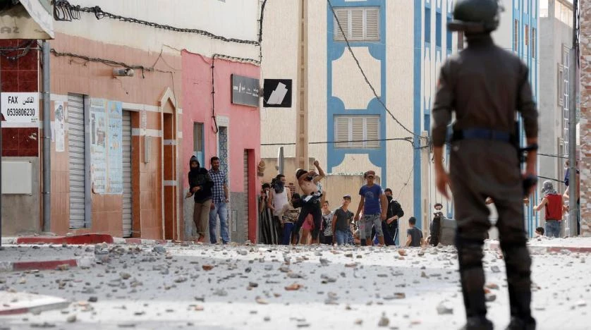Protesters throw stones towards riot police in Morocco. (Reuters)