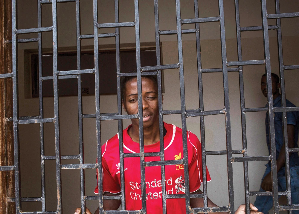 An African migrant peers through a window at Libya’s Karareem detention centre near Misrata, east of Tripoli. Warnings about widespread abuse and deplorable conditions in the detention centers go back at least 15 years. (AFP)