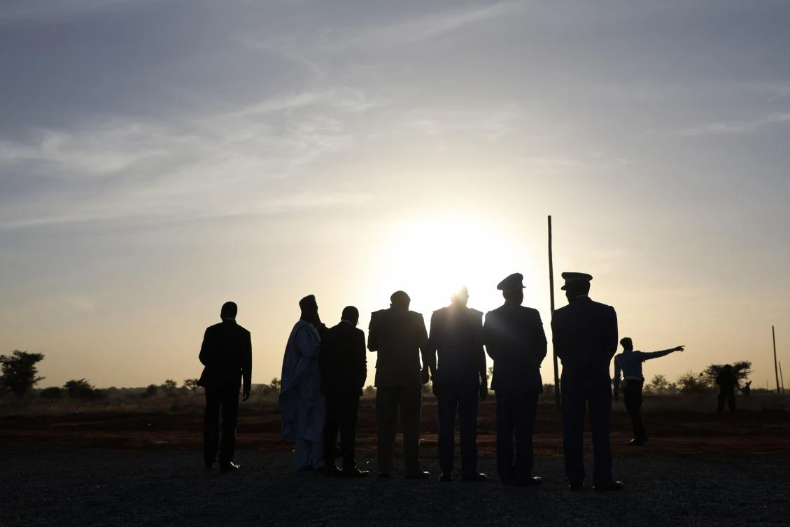 Soldiers stand guard at sunset as France's President and Niger's President Mahamadou Issoufou (unseen) take part in a military ceremony at the Martyr Quarter on December 22, 2019, in Niamey, to pay homage to 71 Nigerien soldiers massacred in an attack on December 10 at the Inates military camp in the Sahel country's western Tillaberi region. (AFP)