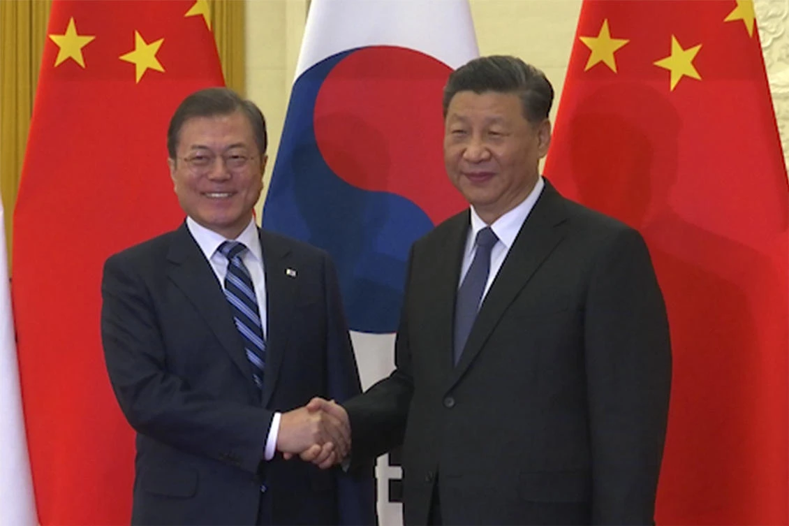 In this image from video, South Korean President Moon Jae-in, left, shakes hands with his Chinese counterpart Xi Jinping as they pose for photographers ahead of their meeting at the Great Hall of the People in Beijing, Monday, Dec. 23, 2019. (AP)