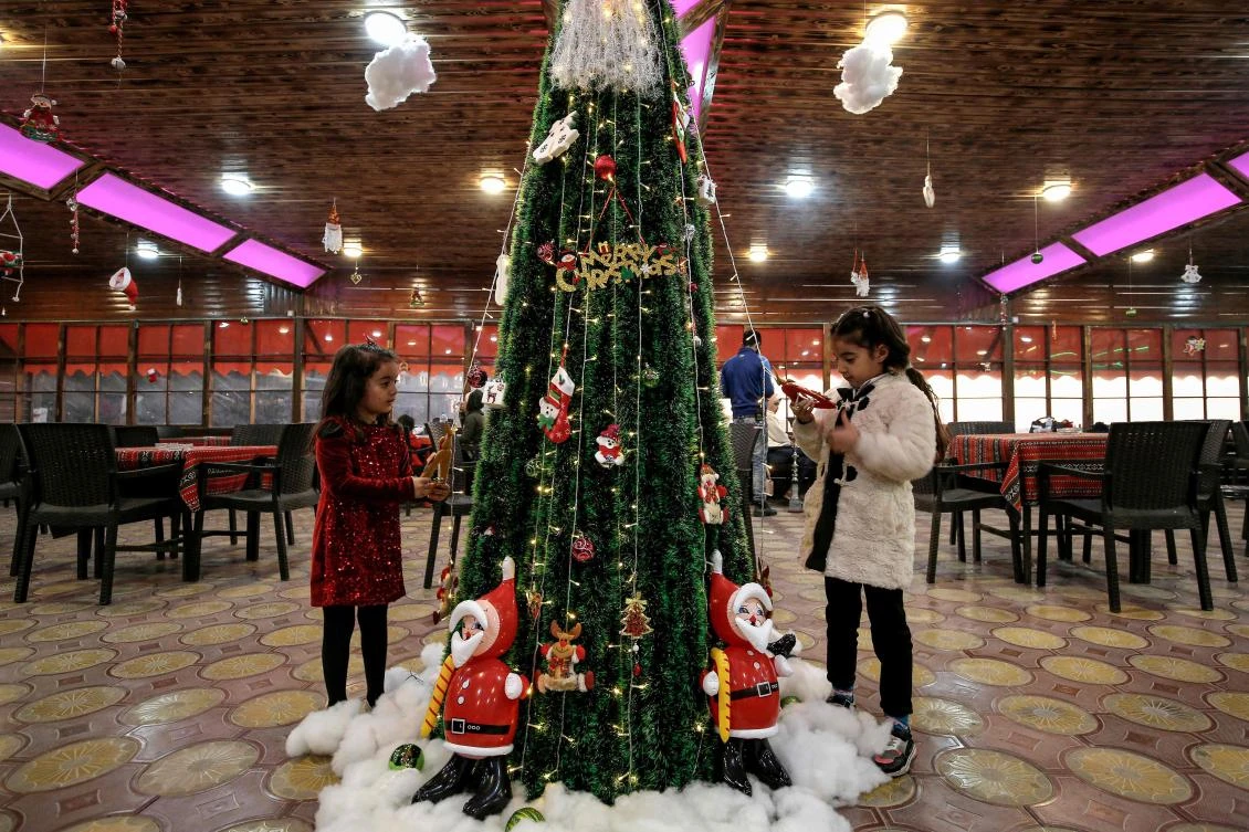 Palestinian children decorate a Christmas tree at a restaurant in Gaza City on December 23, 2019. / AFP / MOHAMMED ABED