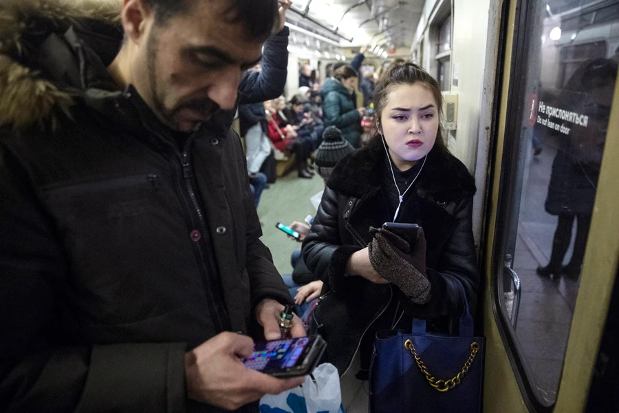 People use their smartphones in a subway train in Moscow, Russia, Monday, Dec. 23, 2019. Russia's Communications Ministry has scheduled an exercise for Monday that is intended to simulate what is being called the isolated operation of the internet. (AP)