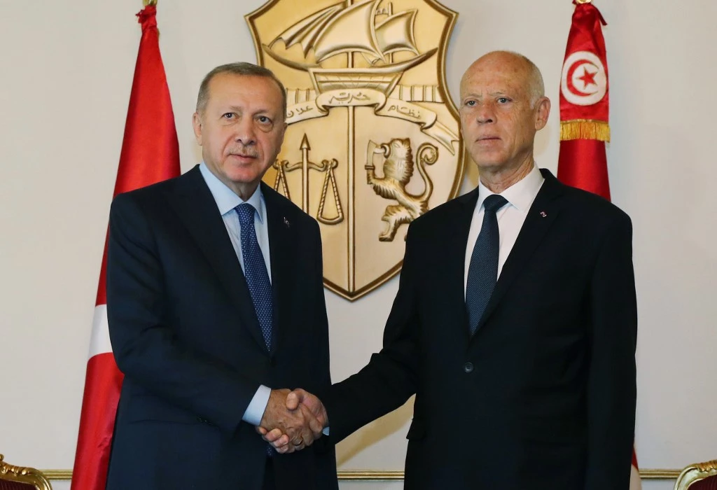 Turkish President Recep Tayyip Erdogan, left, shakes hands with Tunisian President Kais Saied during a welcoming ceremony in Tunis, on December 25, 2019. (AFP)