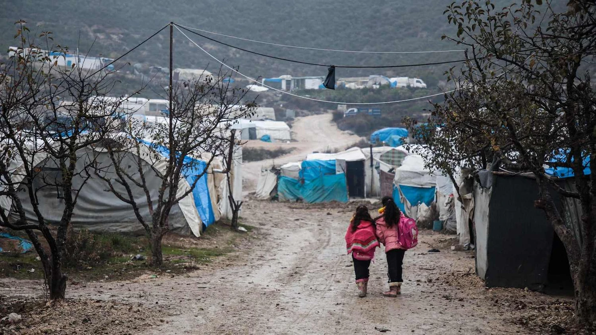 Children walk along a mudpath at a camp for displaced Syrians at Khirbet Al-Joz in the west of the northwestern Idlib province near the border with Turkey. (File/AFP)