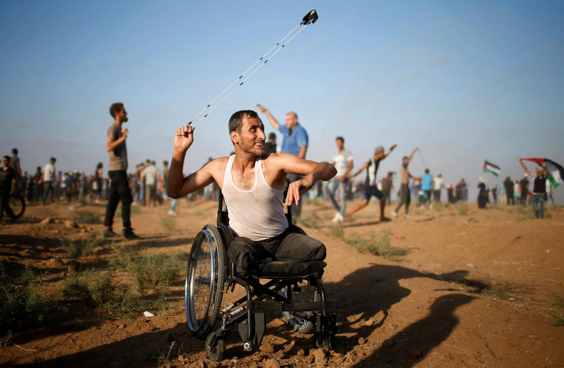 A disabled Palestinian uses a sling to hurl stones at Israeli troops during a protest demanding the right to return to their homeland at the Israel-Gaza border, in Gaza August 17, 2018. (Reuters)