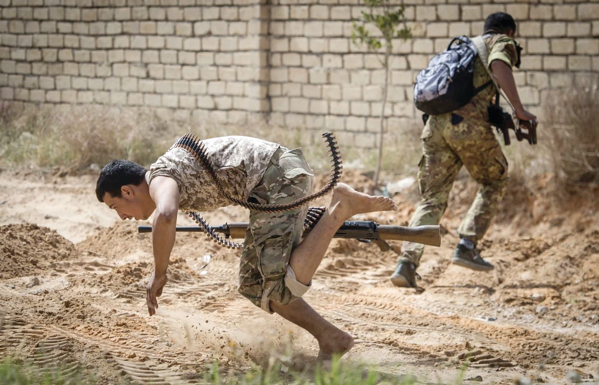 Fighters loyal to the Tripoli administration run for cover during clashes with forces loyal to eastern commander Gen. Khalifa Haftar south of Tripoli. (AFP)