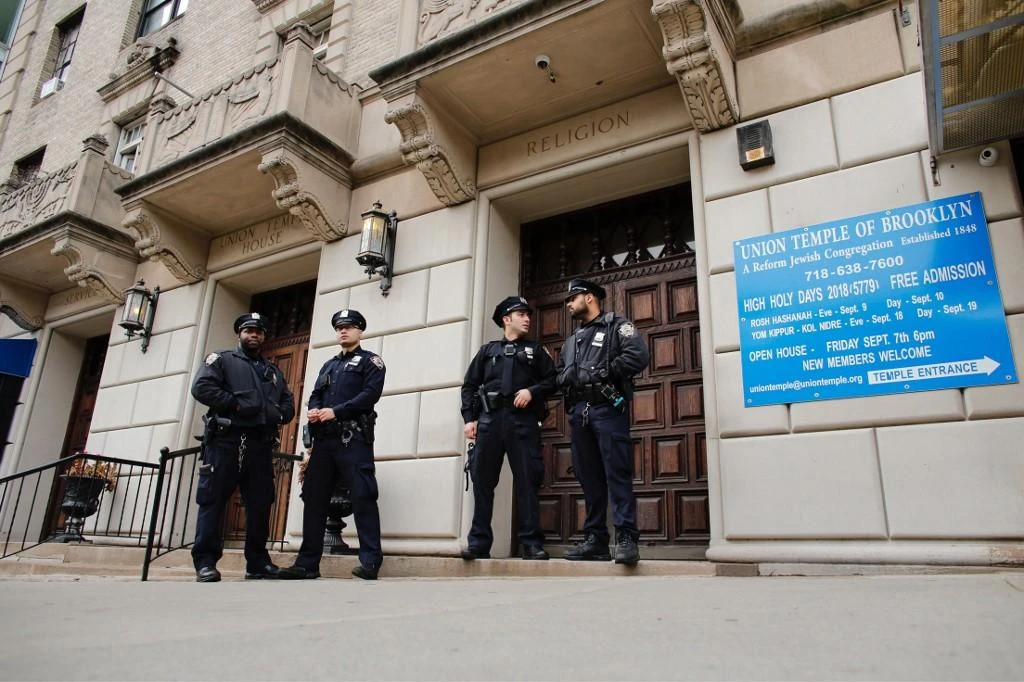NYPD officers stand guard at the door of the Union Temple of Brooklyn after someone drew anti-Semitic graffiti inside. (File/AFP)