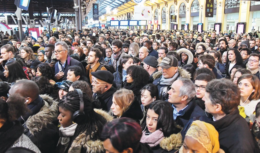 Commuters wait for a train at the Gare Saint-Lazare railway station in Paris during a union strike over government’s plan to overhaul the retirement system. (AFP)