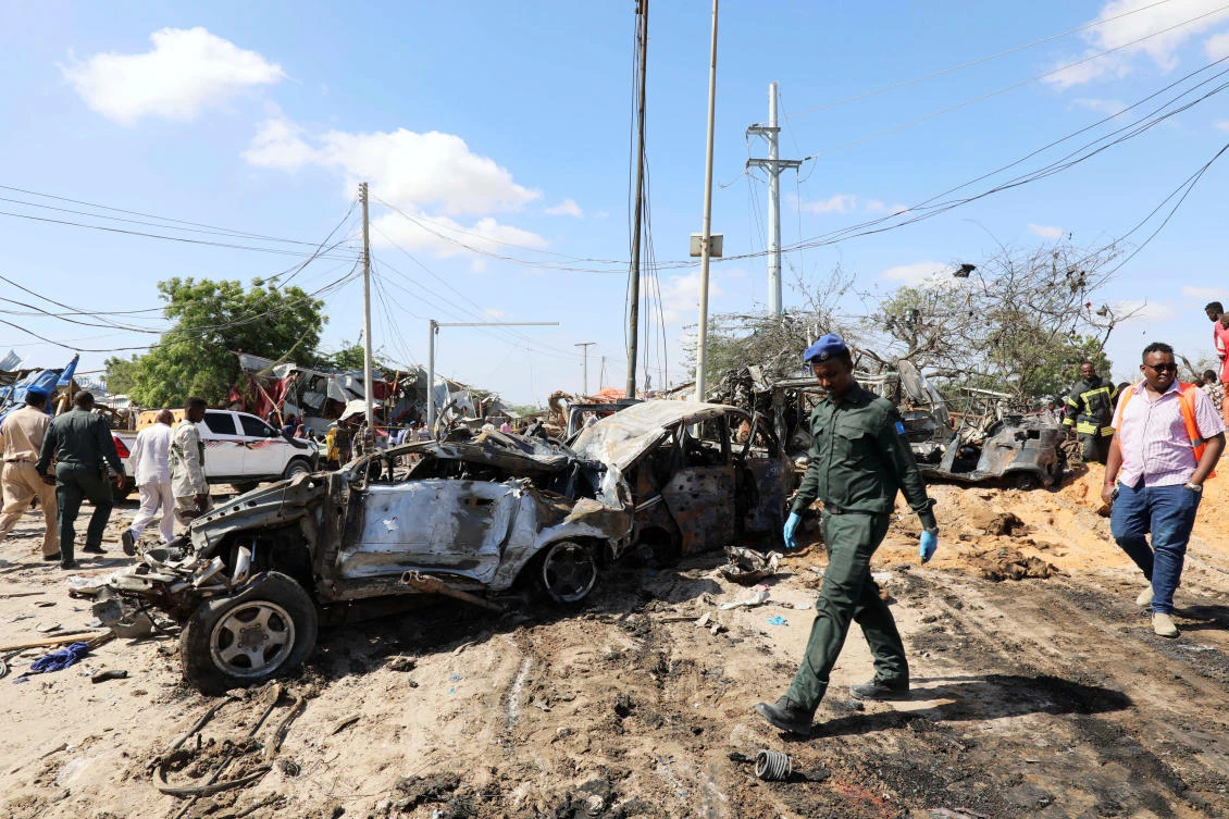 A Somali police officer walks past a wreckage at the scene of a car bomb explosion at a checkpoint in Mogadishu, Somalia December 28, 2019. (Reuters)