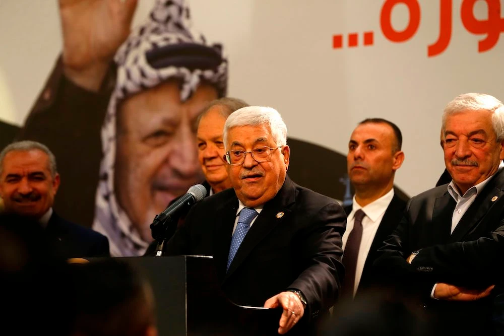 Palestinian President Mahmoud Abbas speaks in front of a picture of late Palestinian leader Yasser Arafat during a ceremony marking the 55th foundation anniversary of the Fatah movement, in the occupied West Bank city of Ramallah on Dec. 31, 2019. (AFP)