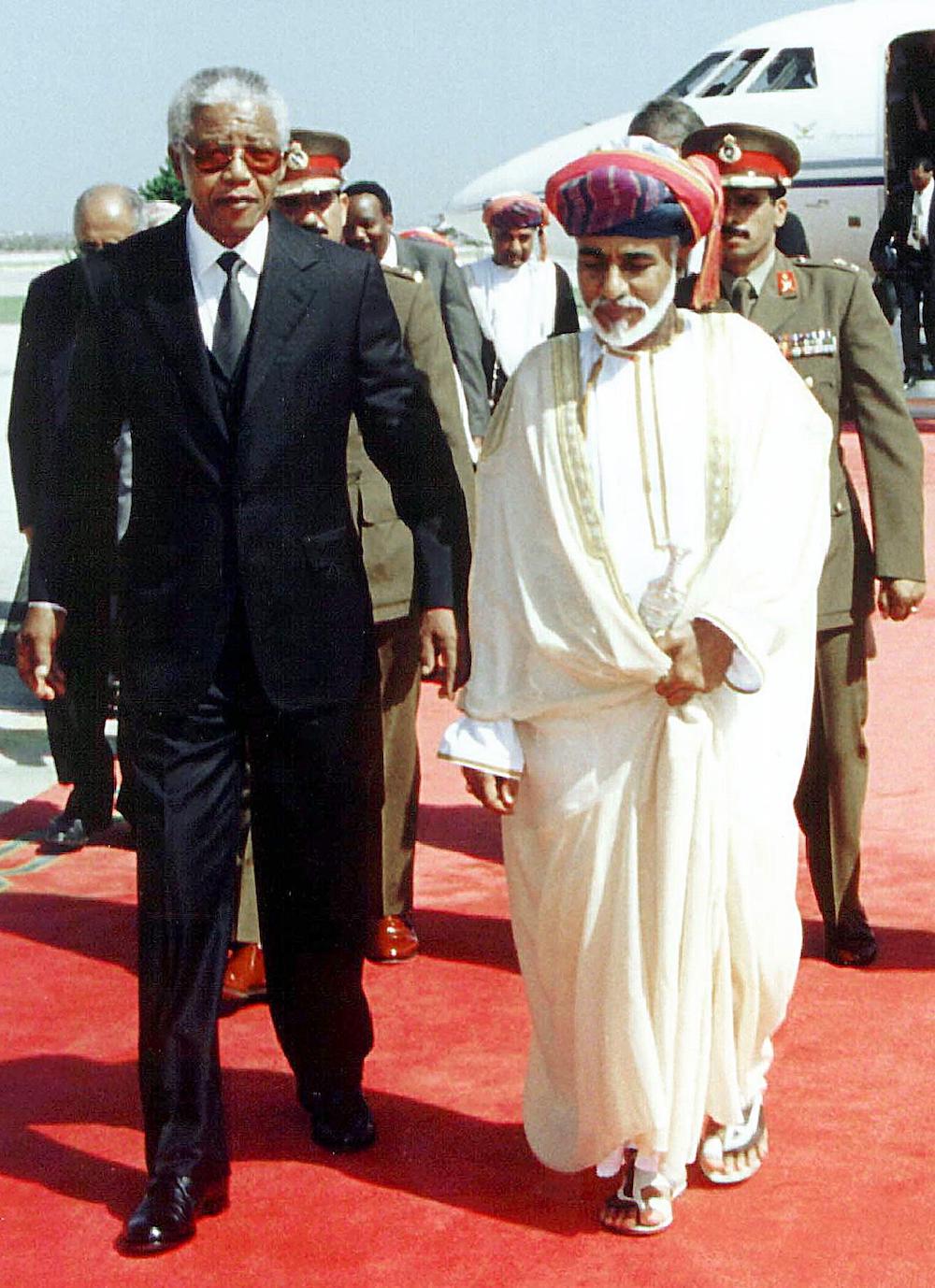 Sultan Qaboos greets South Africa's President Nelson Mandela upon his arrival in Muscat at the start of a Gulf tour in 1999. (AFP/File)