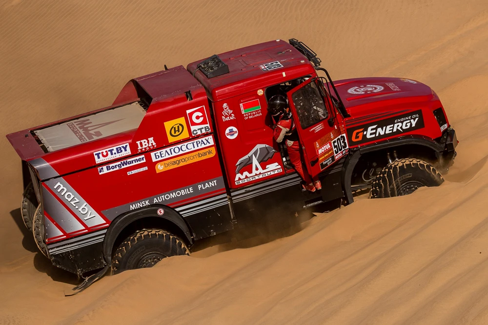 Driver Siarhei Viazovich, of Belarus, and co-drivers Anton Zaparoshchanka, of Belarus, and Pavel Haranin, of Belarus, try to move their MAZ truck after it got stuck in the sand during Stage 8 of the Dakar Rally in Wadi Al Dawasir. (AP Photo)