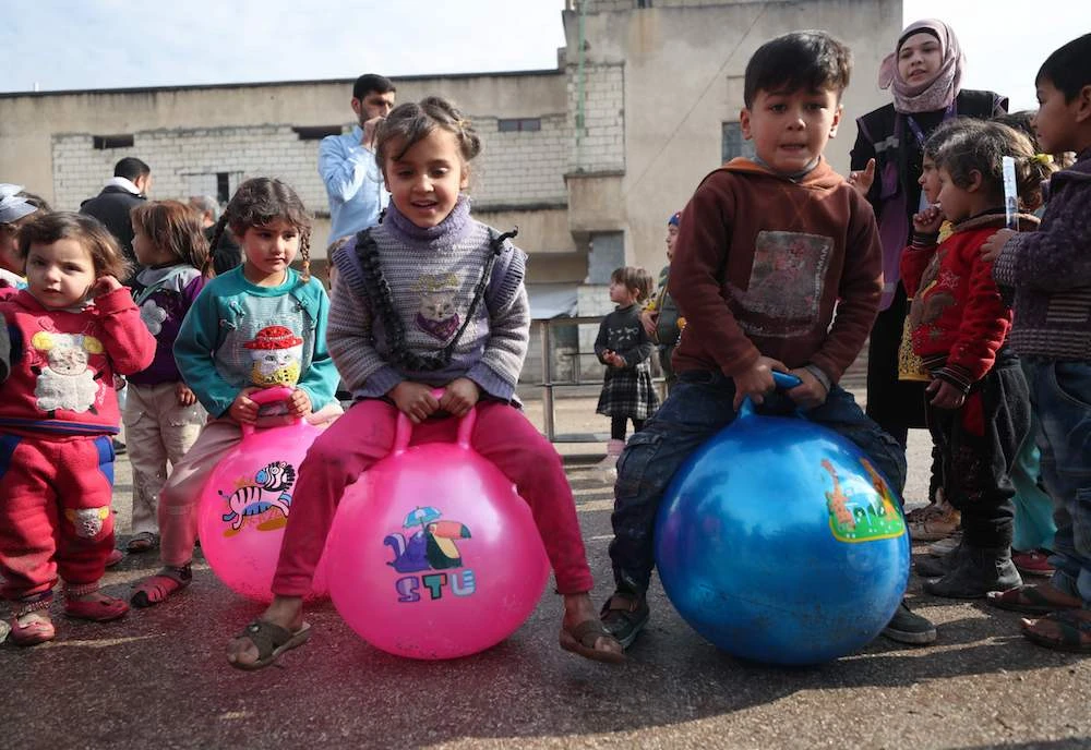 Children of Syrian families displaced from the Maaret Al-Numan region play in the yard of a former jail turned into a makeshift refugee shelter in the northwestern city of Idlib on Dec. 31, 2019, during activities organized by a local aid association. (AFP)