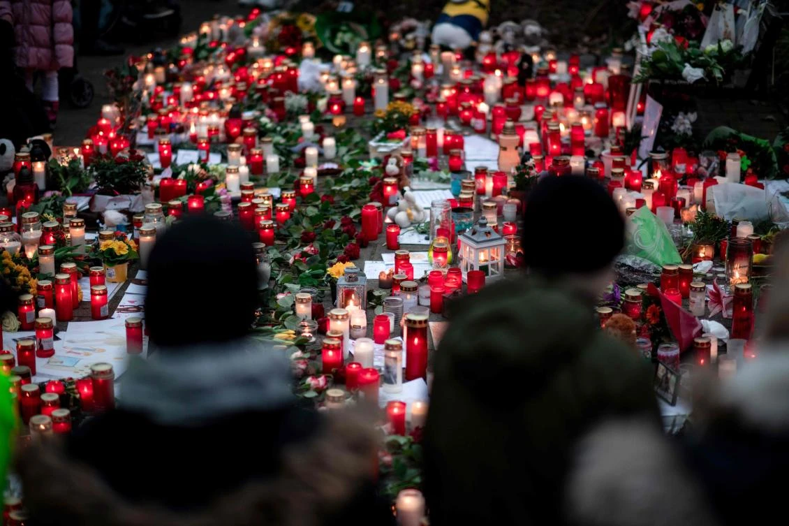 A picture taken on January 2, 2020 shows flowers and candles left at a makeshift memorial site in front of the burned-out monkey house at Krefeld zoo, western Germany, after a fire on New Year's Eve, killed dozens of animals, including orangutans, chimpanzees and marmosets. (AFP)