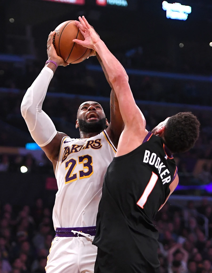 Los Angeles Lakers forward LeBron James drives to the basket and is fouled by Phoenix Suns guard Devin Booker. (Reuters)
